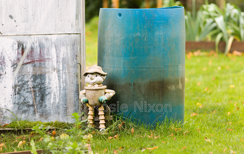 O5A9128 
 a flower pot man clay ornament on the allotment 
 Keywords: allotments, autumn, garden photography, flower pot man, garden, ornament, pots, clay, face, outdoor, happy, turquoise, plastic, bin, paintwork, scratches, texture